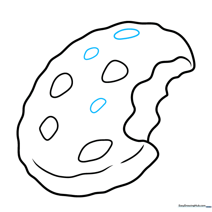 Adding additional chocolate chips to fill the cookie surface.