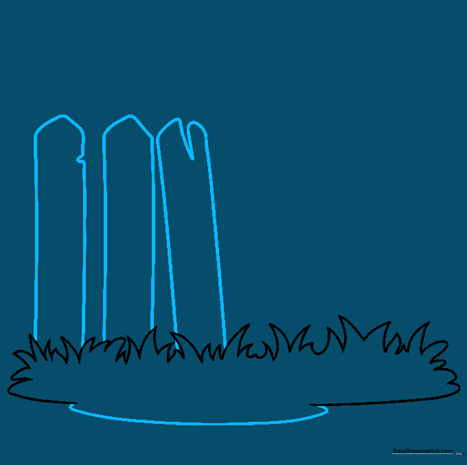 Two vertical wooden pickets with notched tops standing behind the grass.
