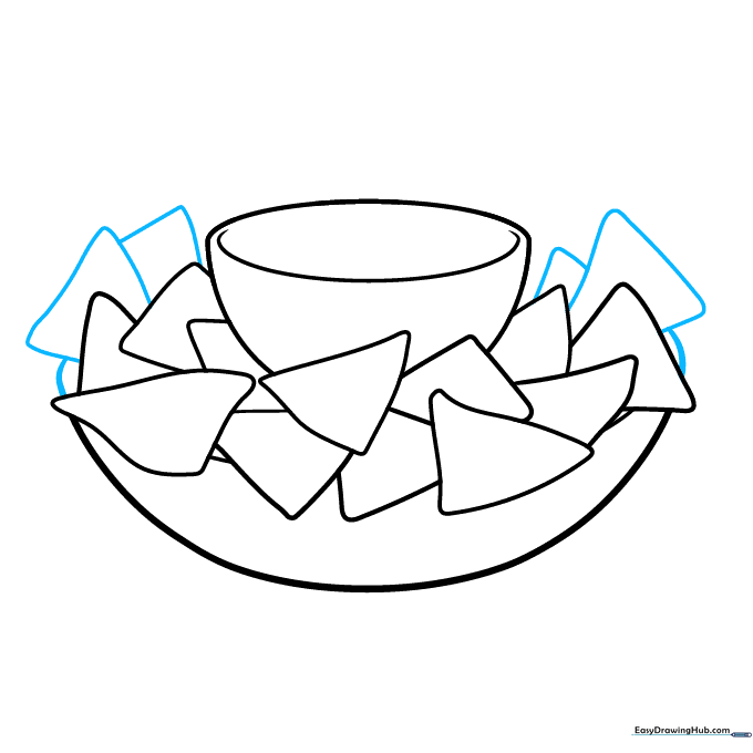 Adding more triangular chips to create a dense, full plate of nachos.