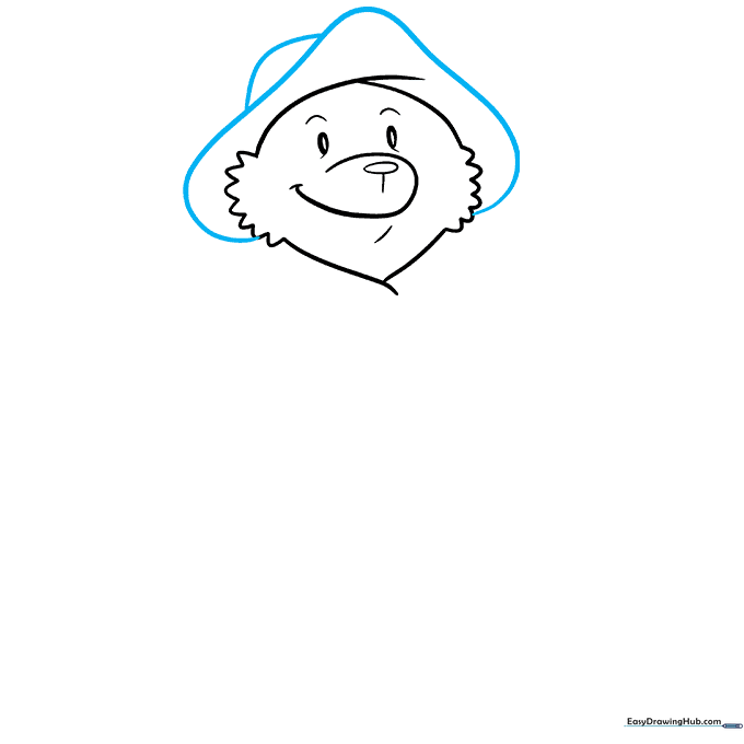 Paddington Bear's iconic red hat being added to the head sketch.